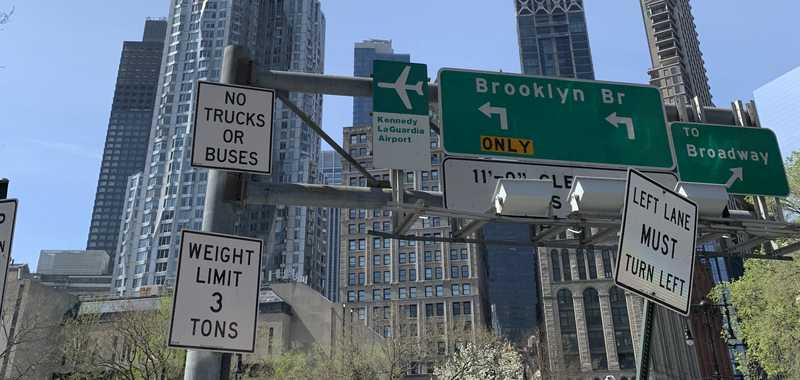 A cacophony of signs at the beginning of the Brooklyn Bridge